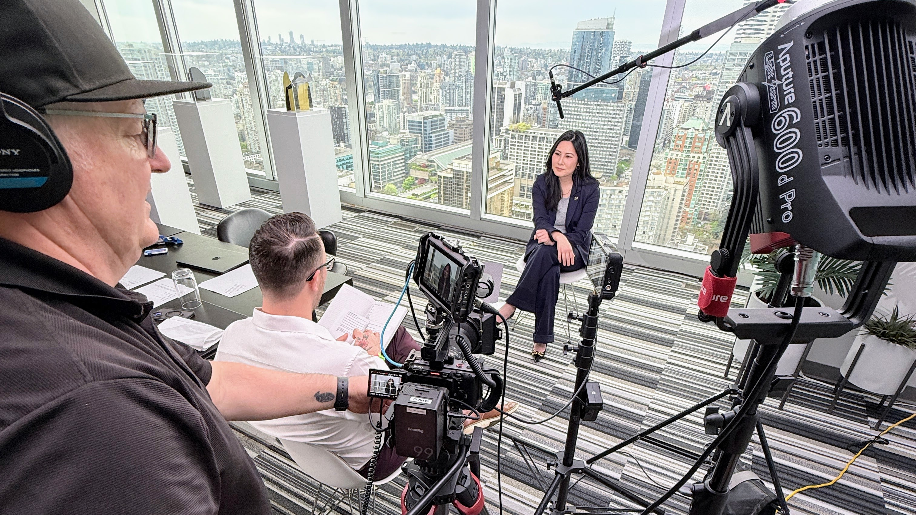 Double H Creative production crew on location filming an executive interview with Vancouver skyline in background