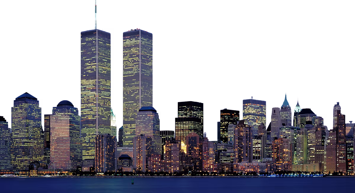 Nighttime skyline of Lower Manhattan with illuminated buildings and the Twin Towers prominently visible.