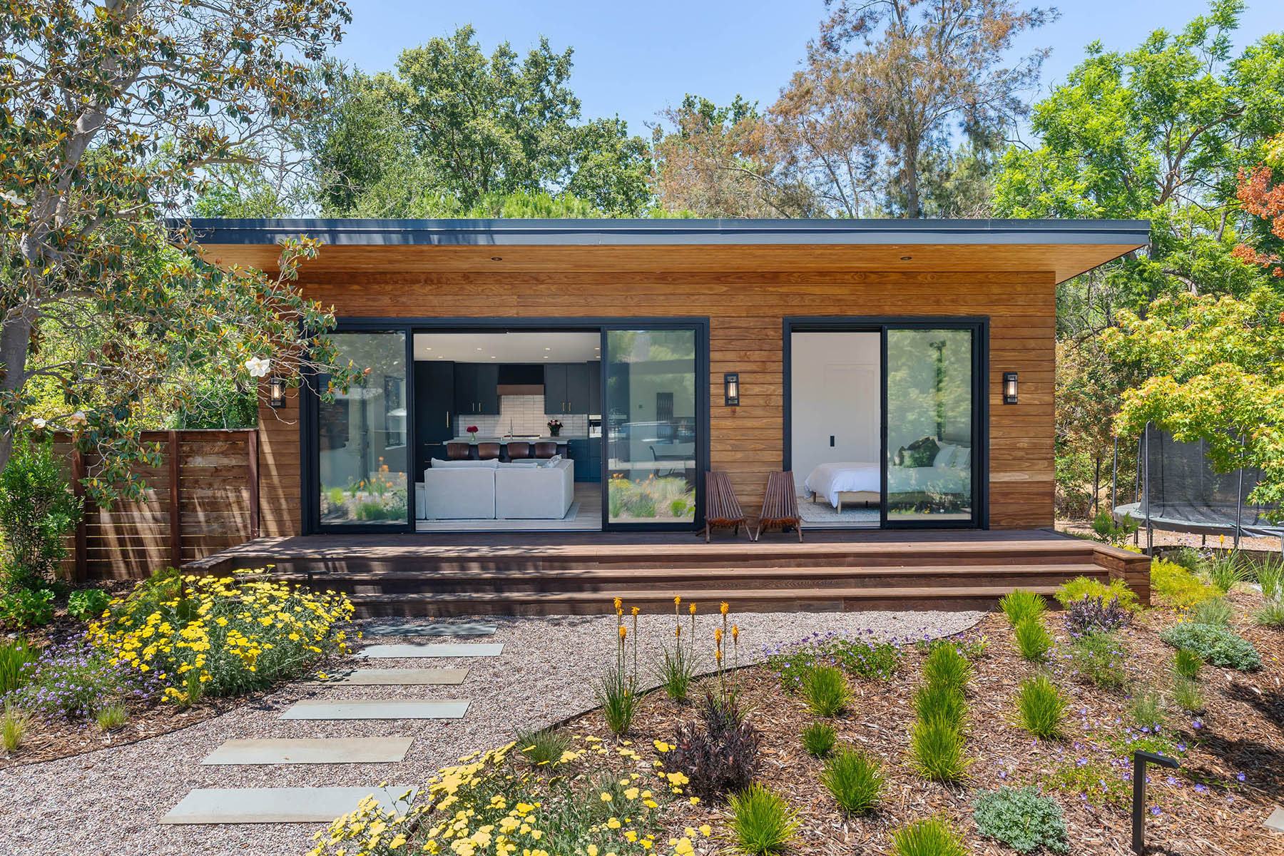 Modern Accessory Dwelling Unit (ADU) with large sliding glass doors and deck opening to a native plant garden in Los Altos Hills
