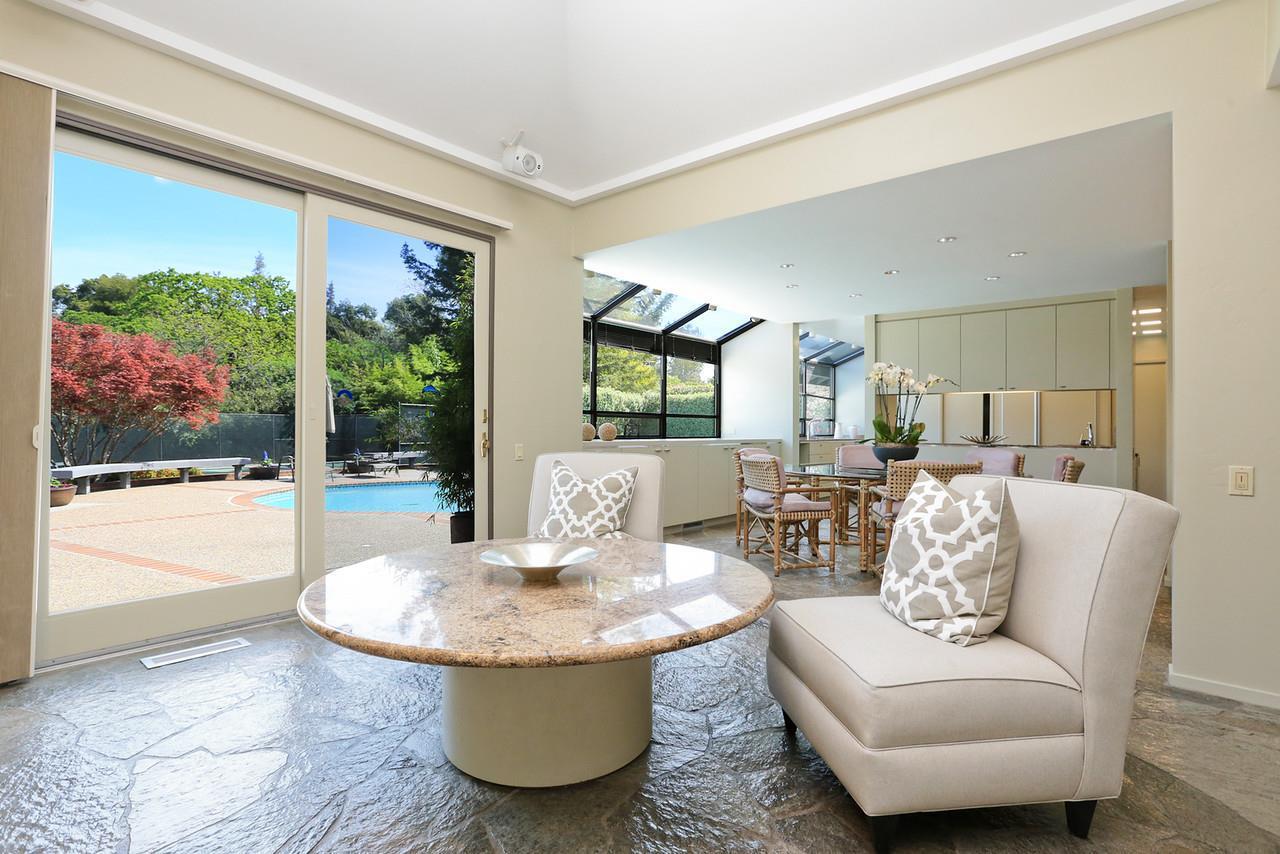 Existing dining area adjacent the kitchen with large sliding glass door opening to a pool and garden.