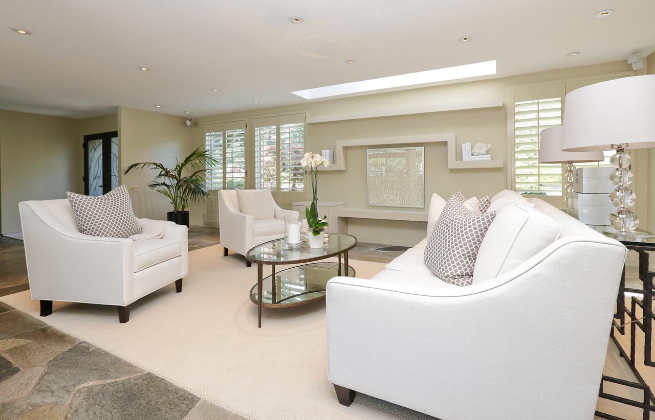 Original living room with 8' flat ceilings and built-in shelves below a long skylight at the central wall