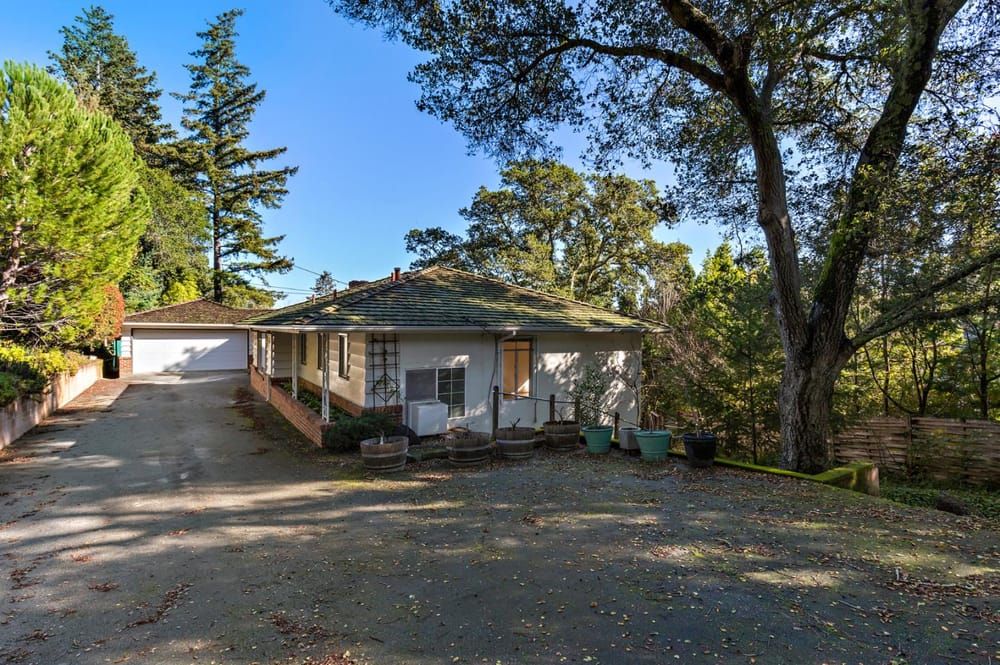 Single-story house with a paved driveway leading to a detached garage.