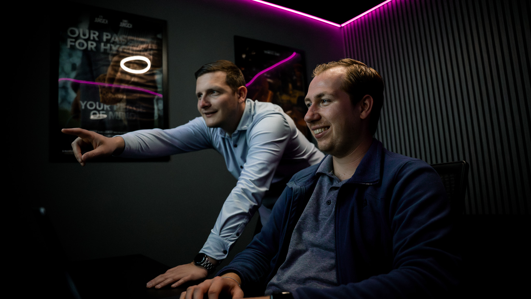 Twee editors in de edit suite met paarse neonverlichting