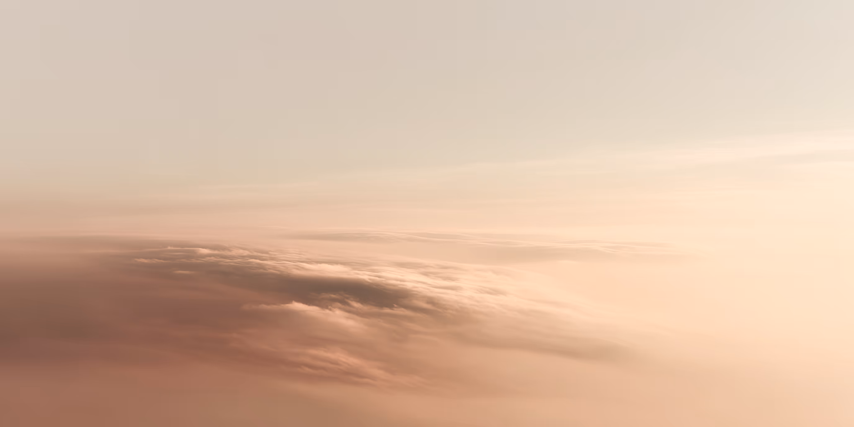 Softly illuminated clouds under a pale sky during sunrise or sunset.