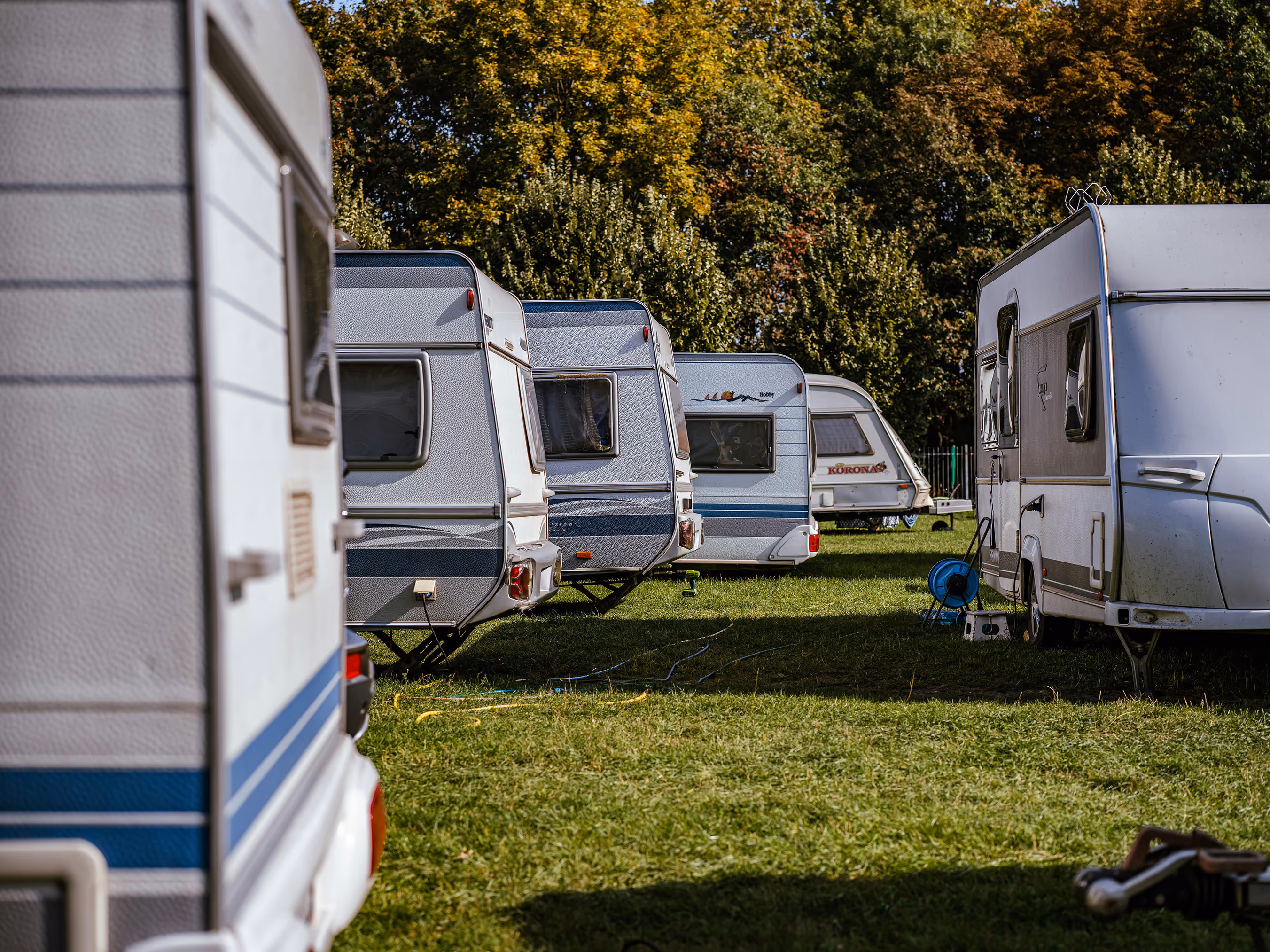 Et billede af en campingplads med flere campingvogne der er parkeret tæt.