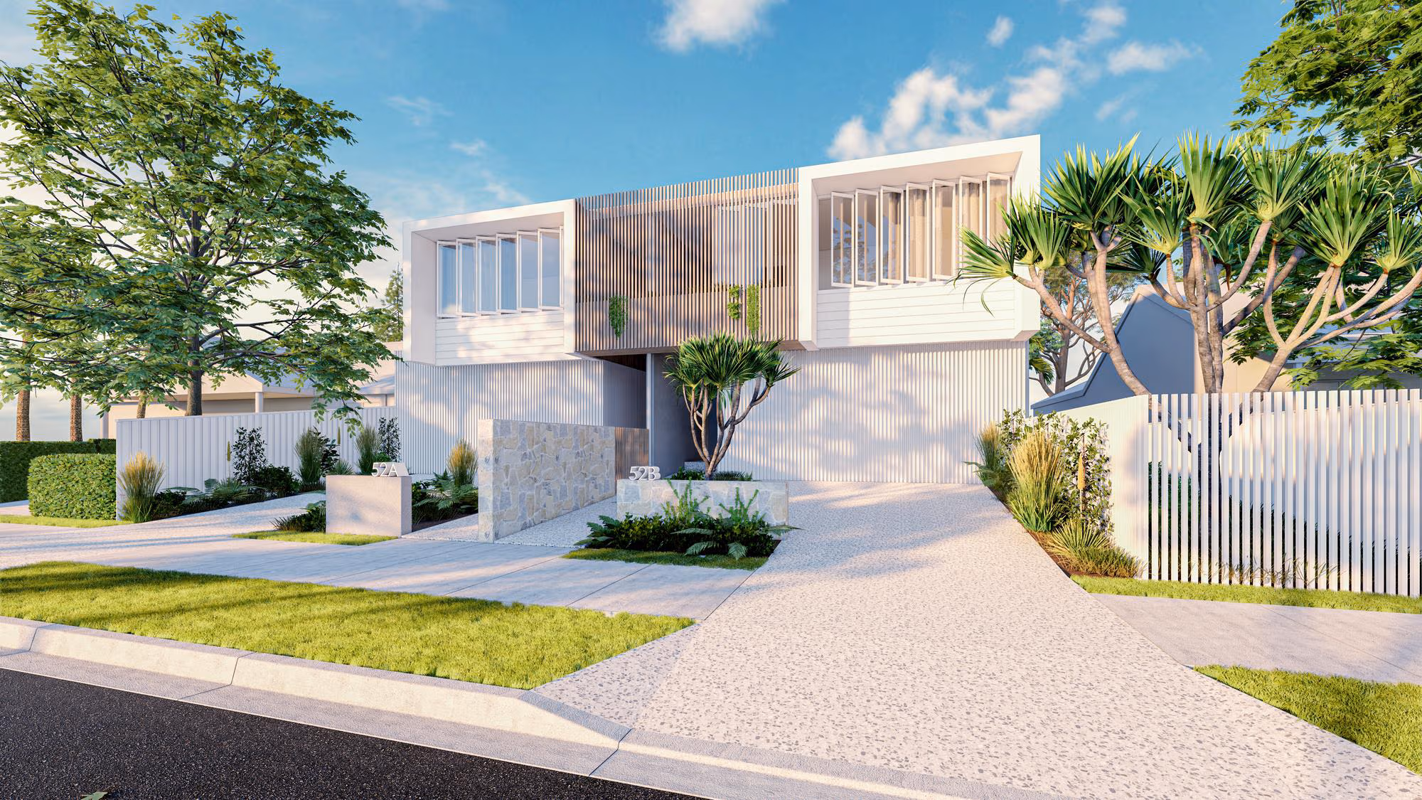 Modern two-story duplex with white exterior, large windows, a stone dividing wall, landscaped front yard, and a clear blue sky.