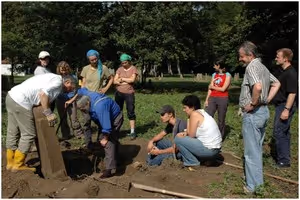 Un groupe de personnes autour d'un trou creusé dans le sol dans le cimetière juif de Mackenheim