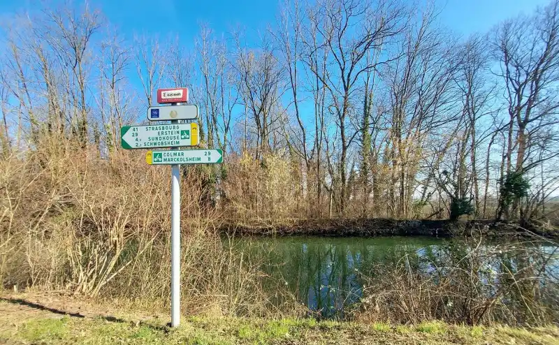 paneau montre les directions pour la piste cyclable à côté de la rivière