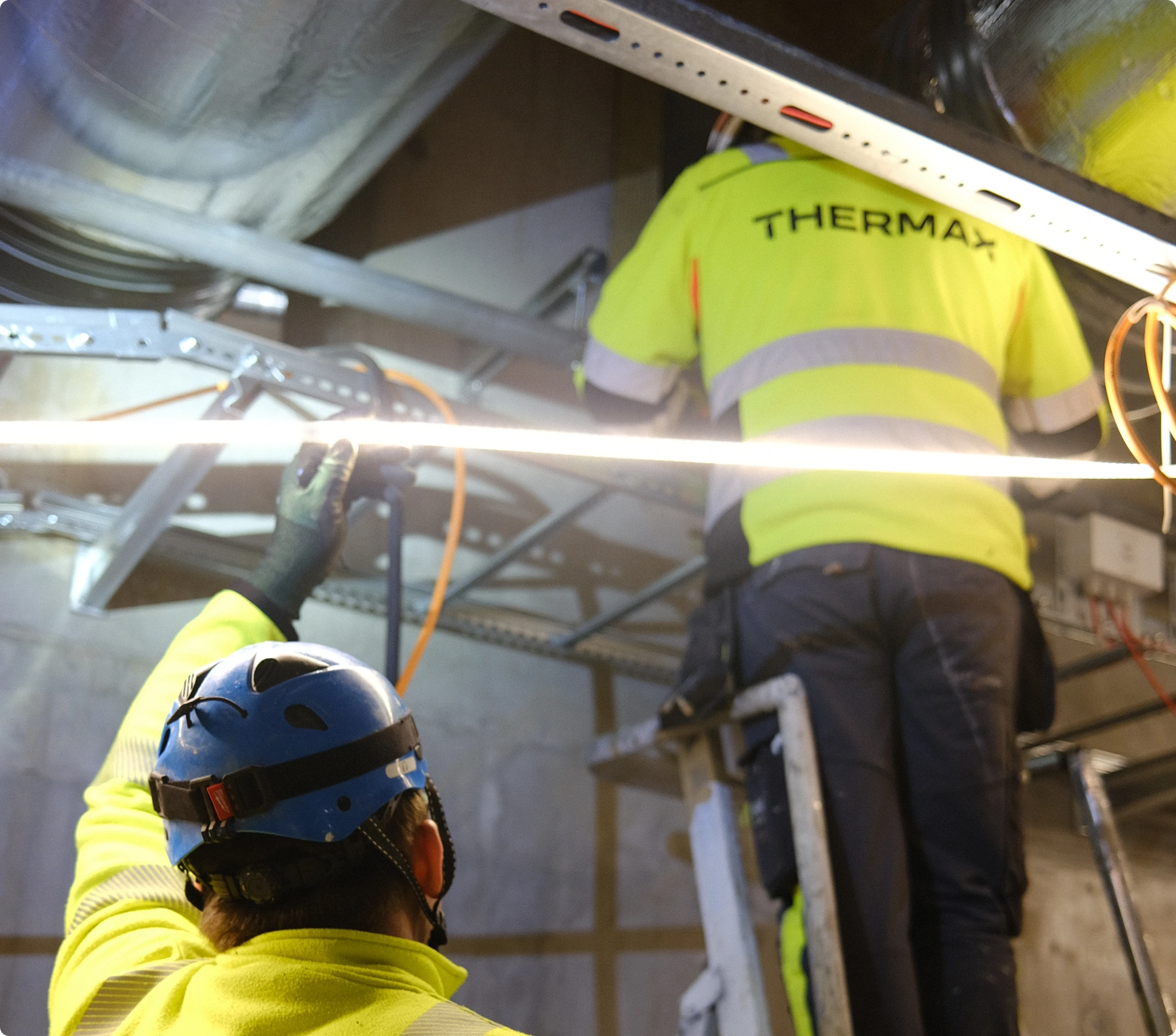 To brannsikrere i gul jakke med navnet thermax på 