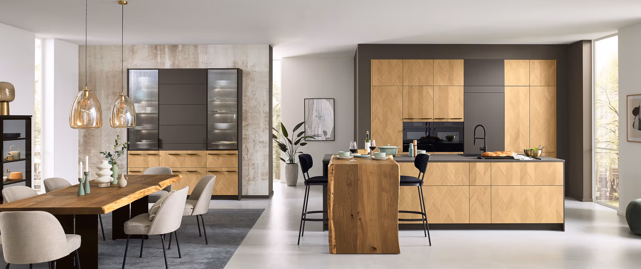 Moderne offene Küche und Esszimmer mit hellen Holzschränken, schwarzer Spüle, Esstisch aus Naturholz und beigen Stühlen.