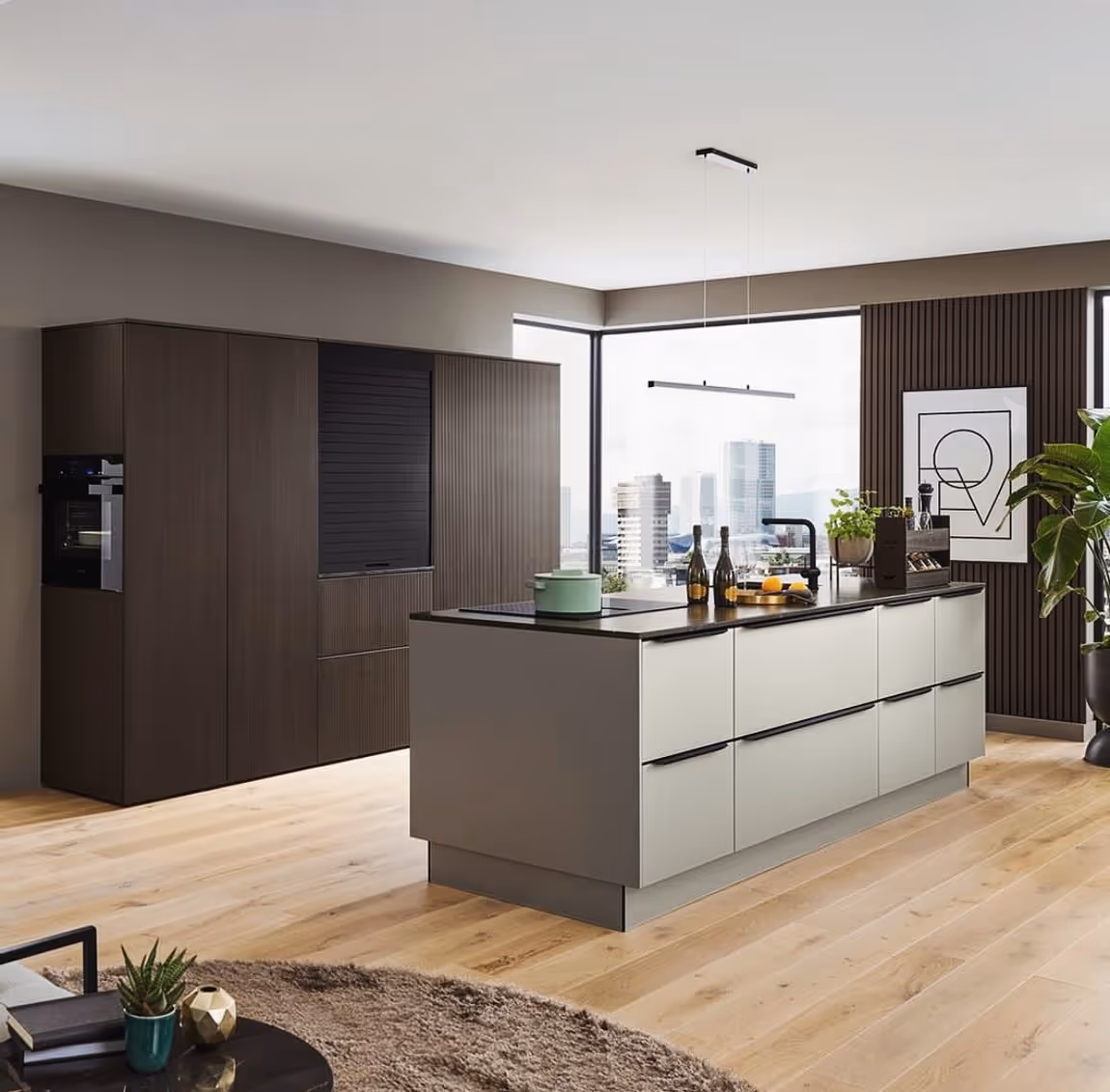 Moderne Küche mit einer großen Insel in neutralen Farben, Holzschränken, Holzboden, Pflanzen und großer Fensterfront mit Stadtblick.