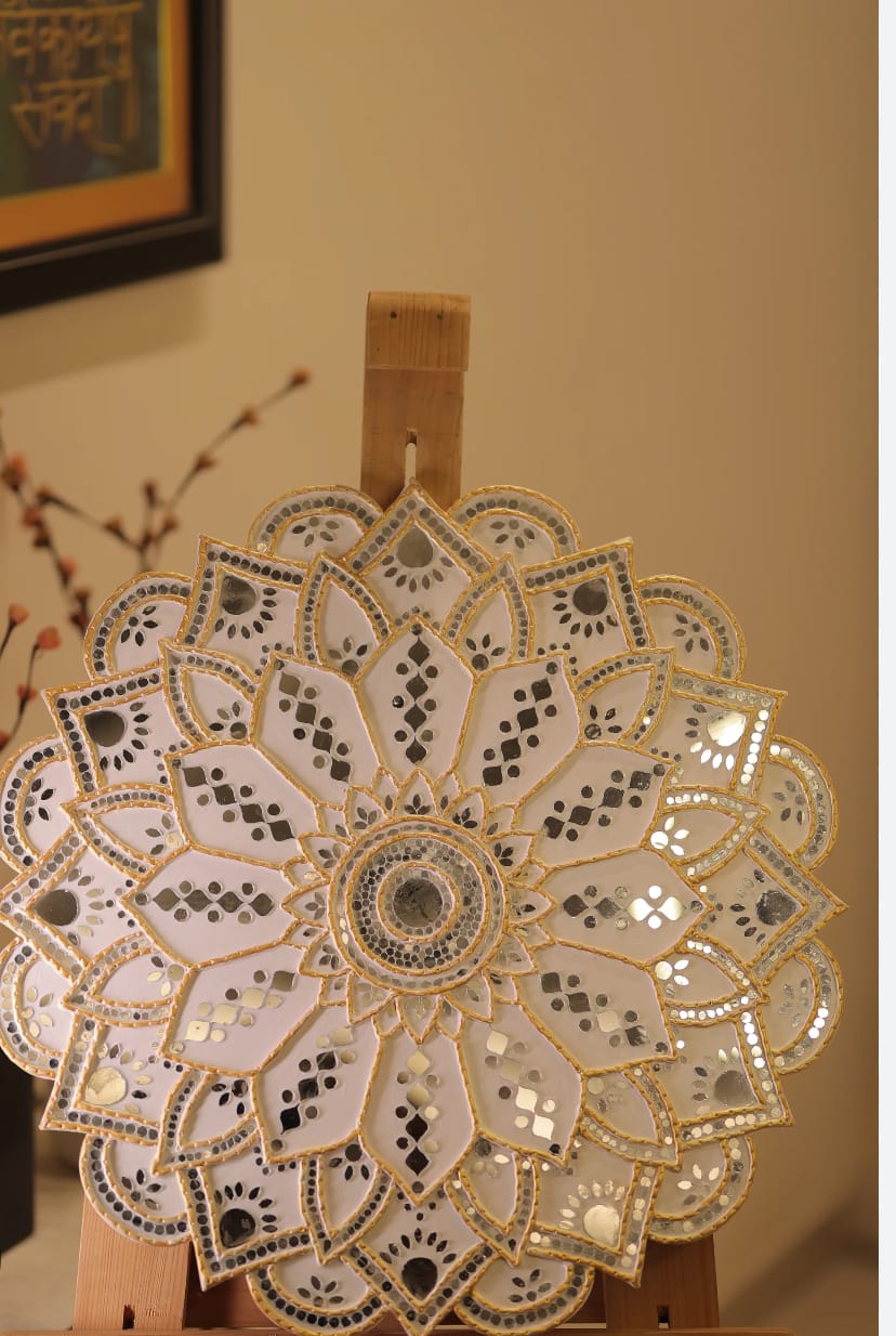 Cozy café interior with hanging lights, a brick wall, and wooden shelves. A counter with coffee equipment and pastries creates a welcoming, warm ambiance.