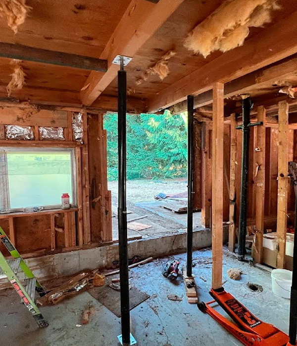 Before ADU basement remodel showing framed structure transformed into finished living space with kitchen and sofa
