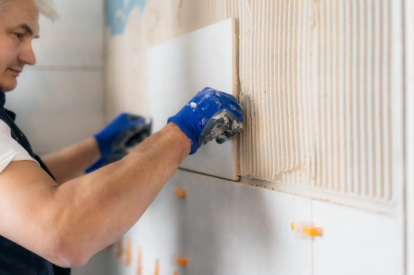 A contractor installing a new kitchen backsplash to protect the walls in a Bellevue home