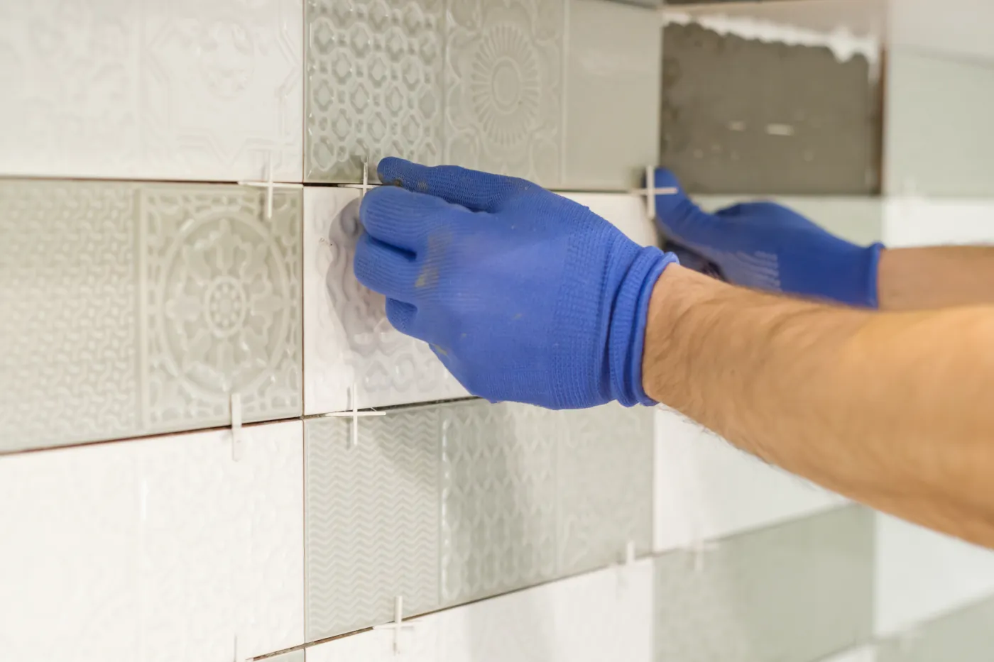 A kitchen wall being tiled during backsplash installation process