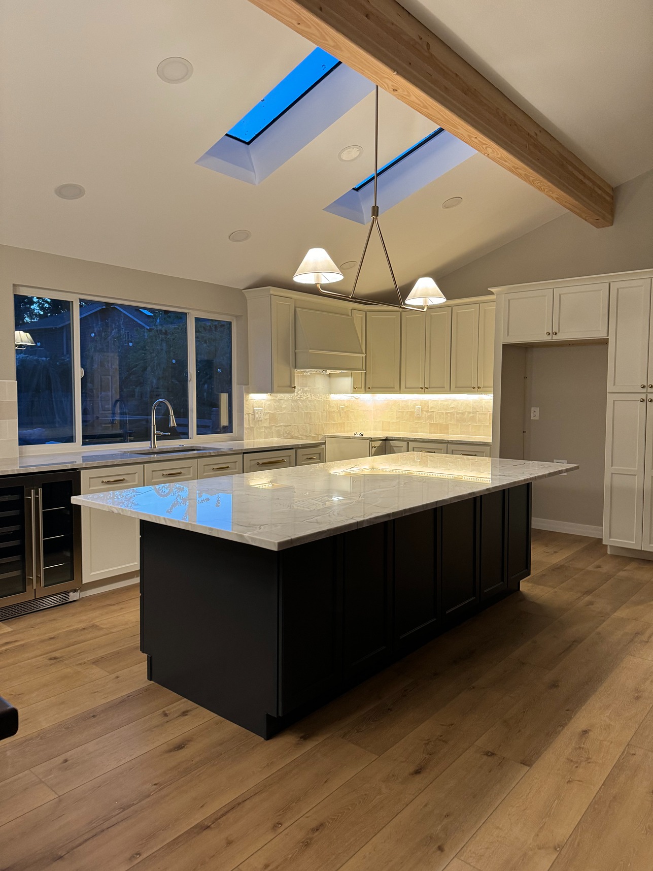 A newly installed kitchen countertop in an Everett home, with wooden floors and furnished white kitchen cabinets 