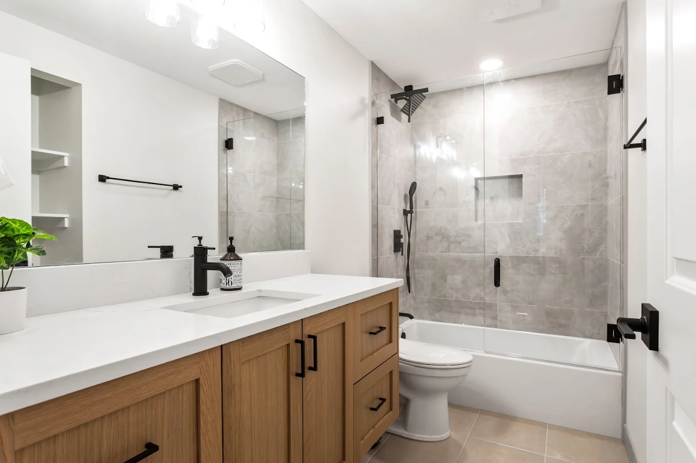 Standard alcove tub converted to a modern walk-in shower with tile walls and glass doors in Bothell WA