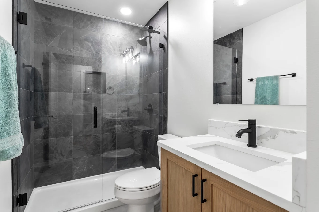 Modern walk-in shower with natural stone wall tiles converted by CraftHaus in a Bothell WA home