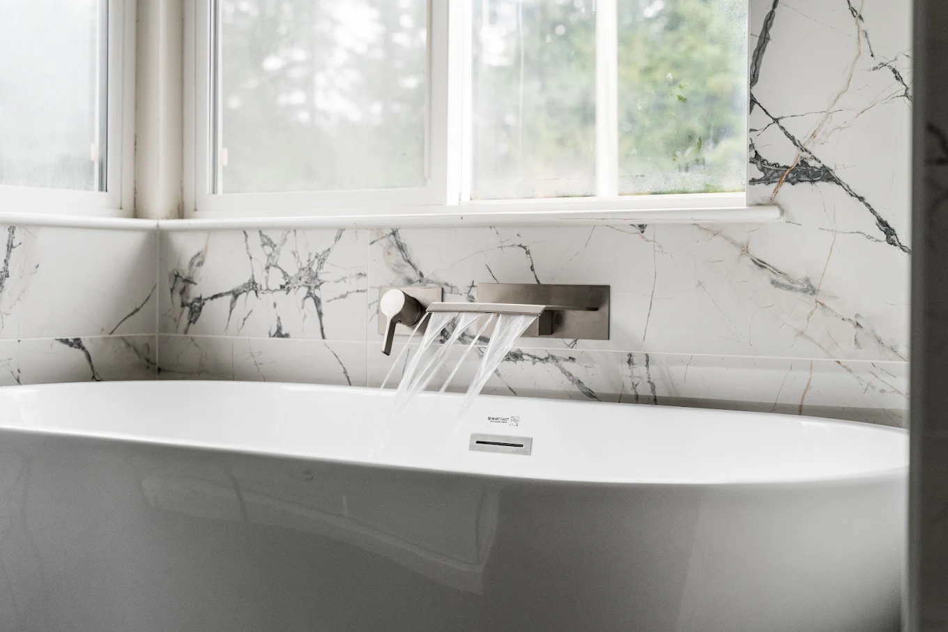 Freestanding tub with faucet attached to a ceramic-tiled wall in Bothell