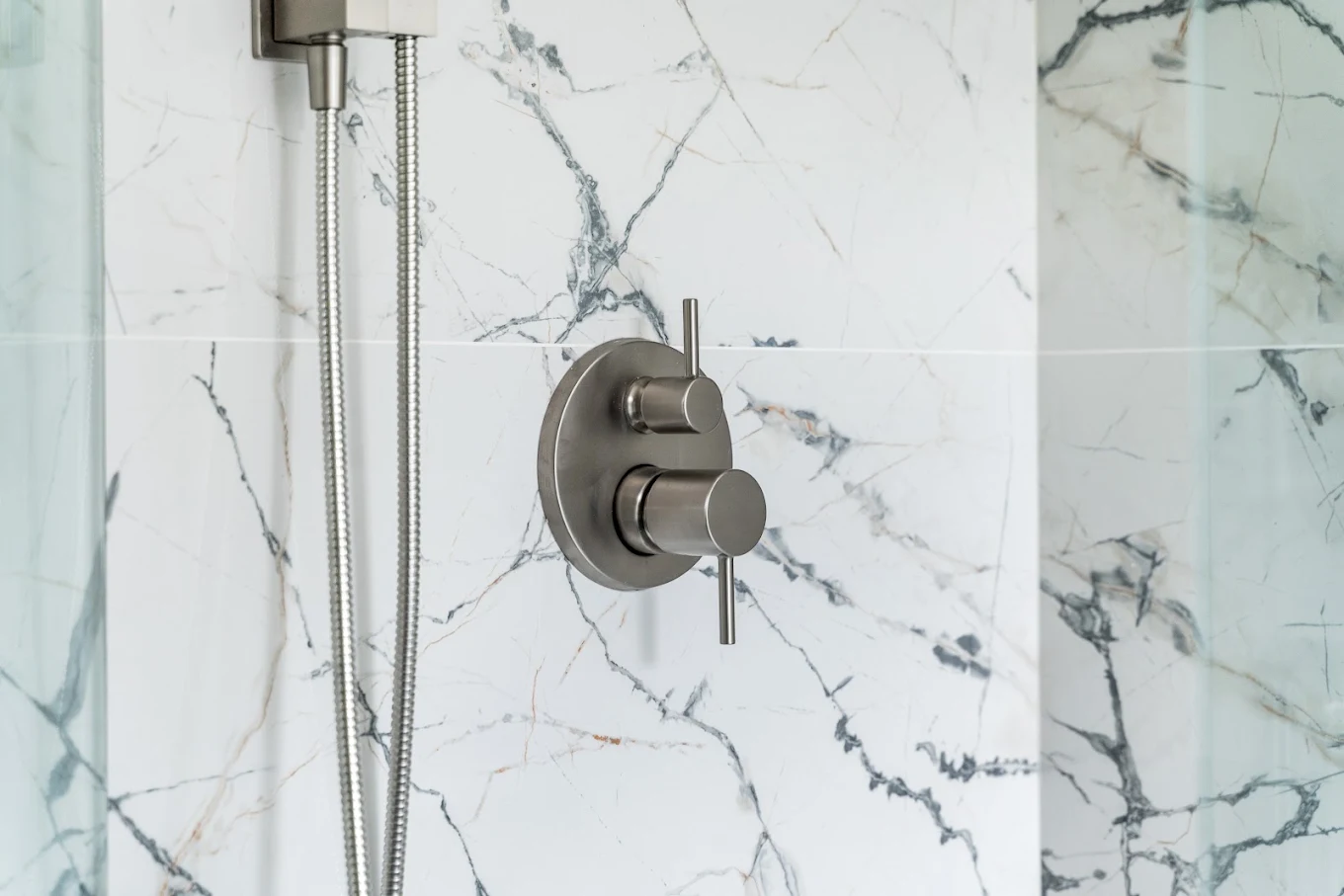 Hot and cold shower taps installed in a ceramic-tiled wall in Bothell