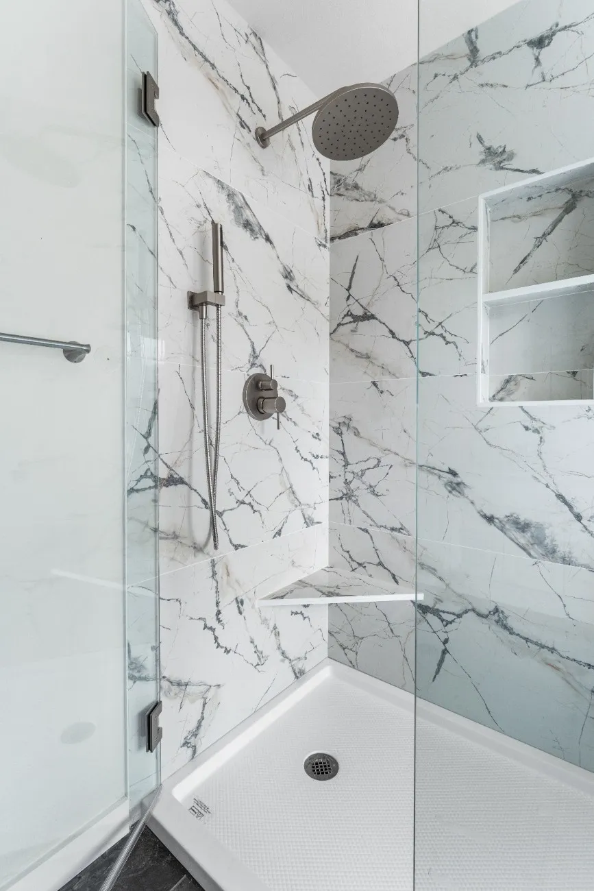 Custom tiled shower with a large-format porcelain wall and arched niche in Bothell, WA