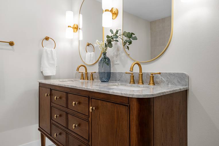 Double-sink vanity with brass fixtures in a Bothell primary bathroom