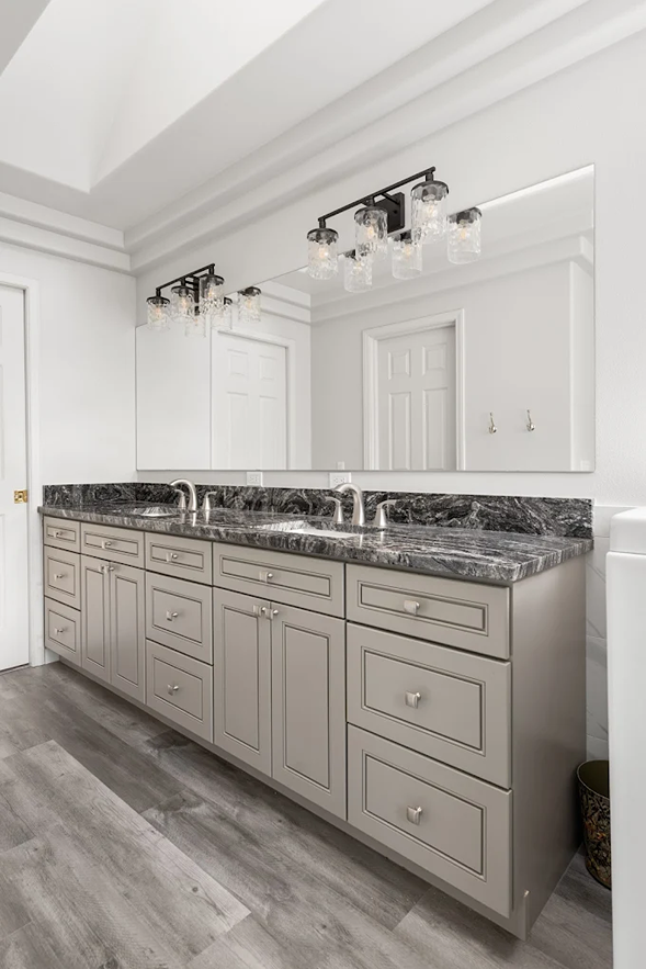 Drawers and cabinets beneath a double vanity sink with full-length mirror in Bothell 