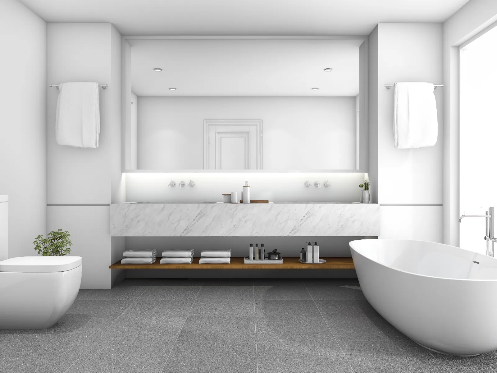 Minimalist white bathroom with a freestanding oval bathtub, wall-mounted toilet, long marble vanity with under-shelf storage