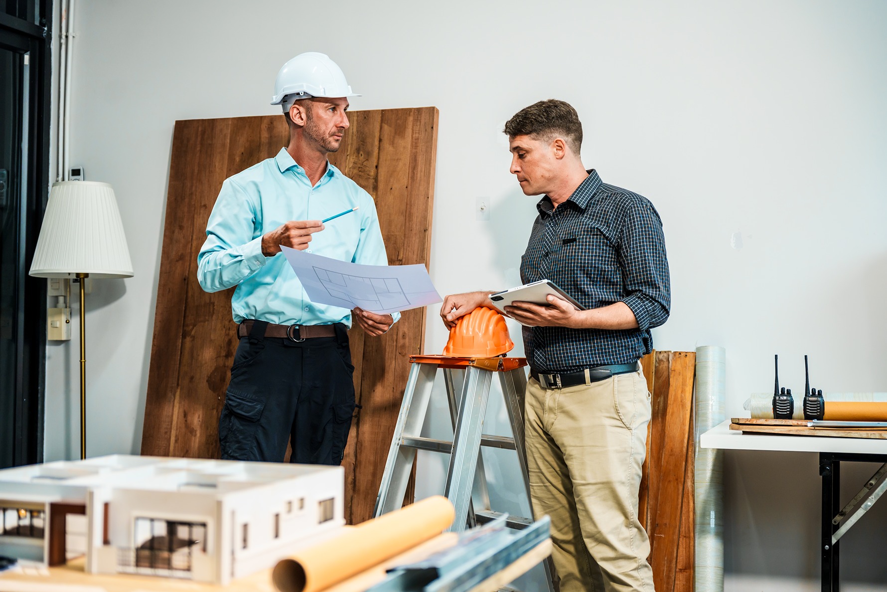 Contractor reviewing gut renovation timeline and design plans with homeowner