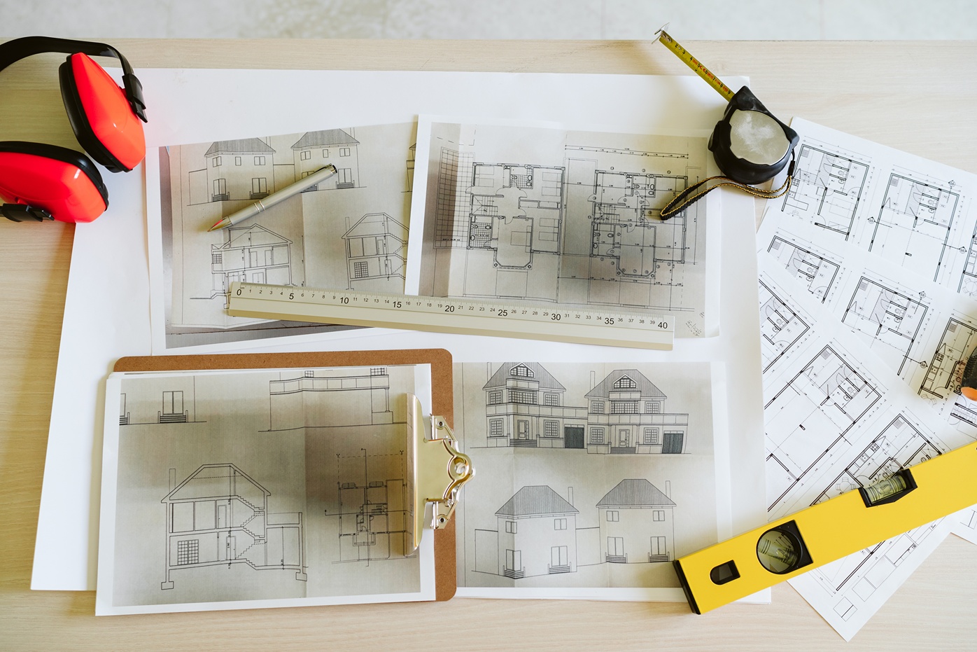 home building process schematic design and working drawings on a desk