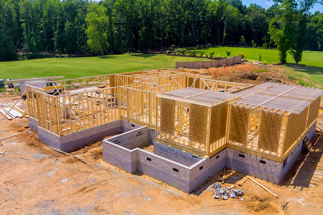 Luxury home construction site showing foundation and framing