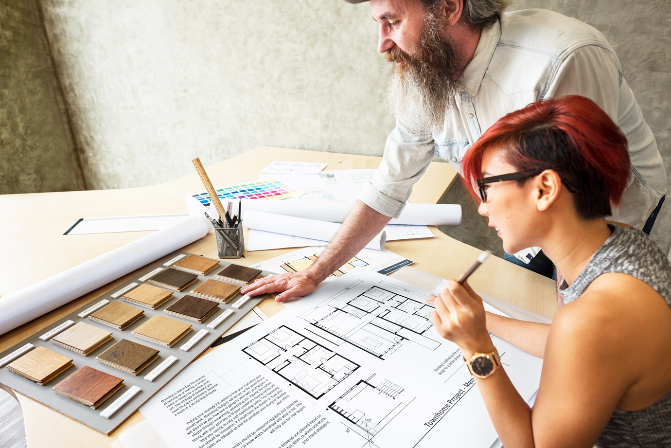 Home builder and homeowner reviewing a custom home floor plan and material selections during the design process
