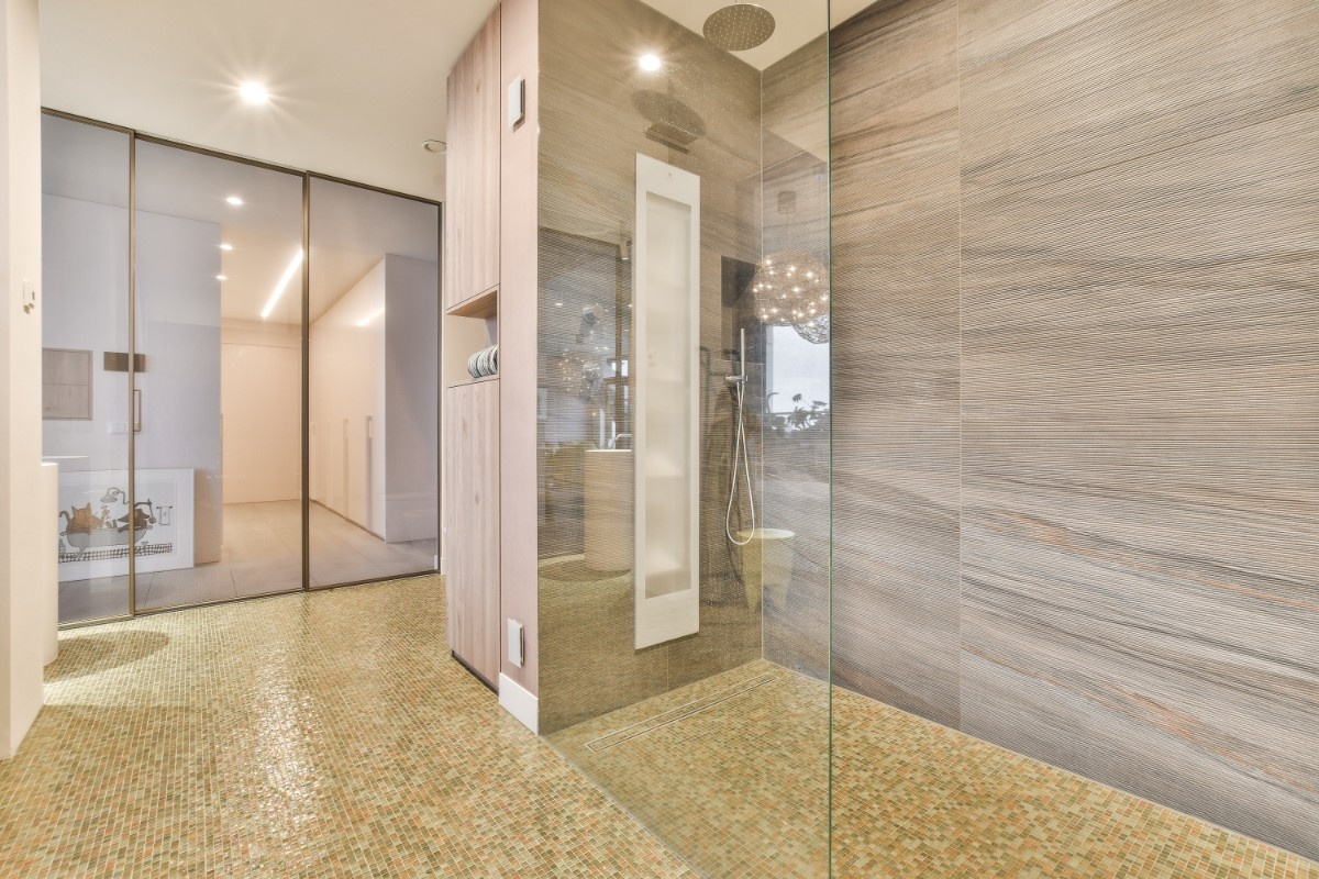 Primary suite walk-in shower with glass panels and curbless entry