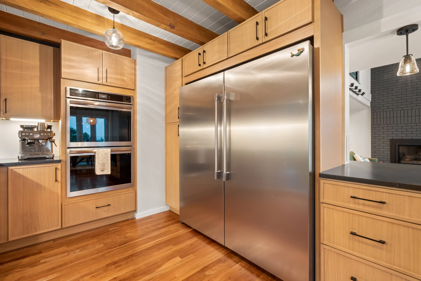 Close-up of a built-in refrigerator and wall ovens set into custom cabinetry in a CraftHaus kitchen remodel near Cottage Lake