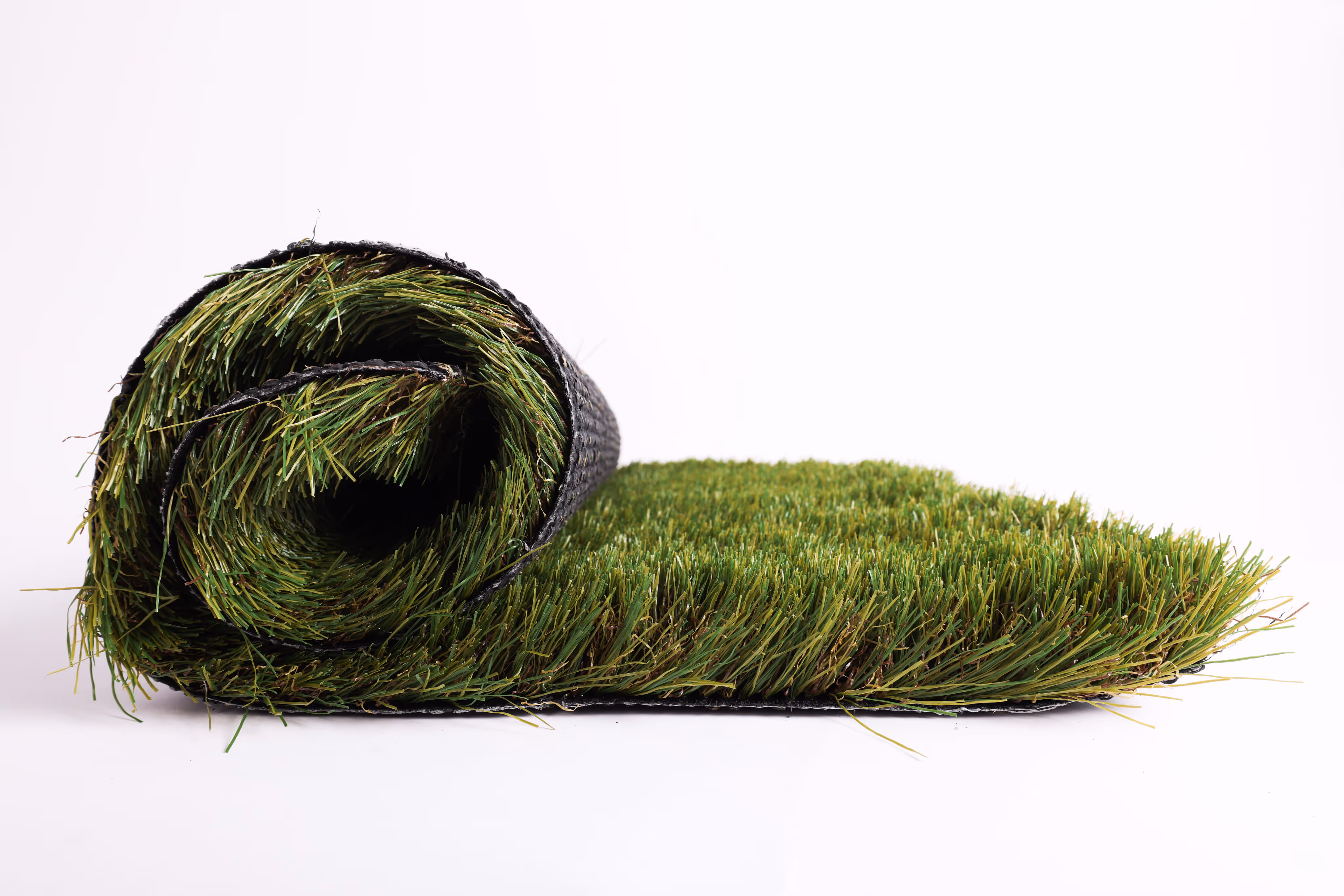Rolled-up section of artificial green grass turf on a white background.