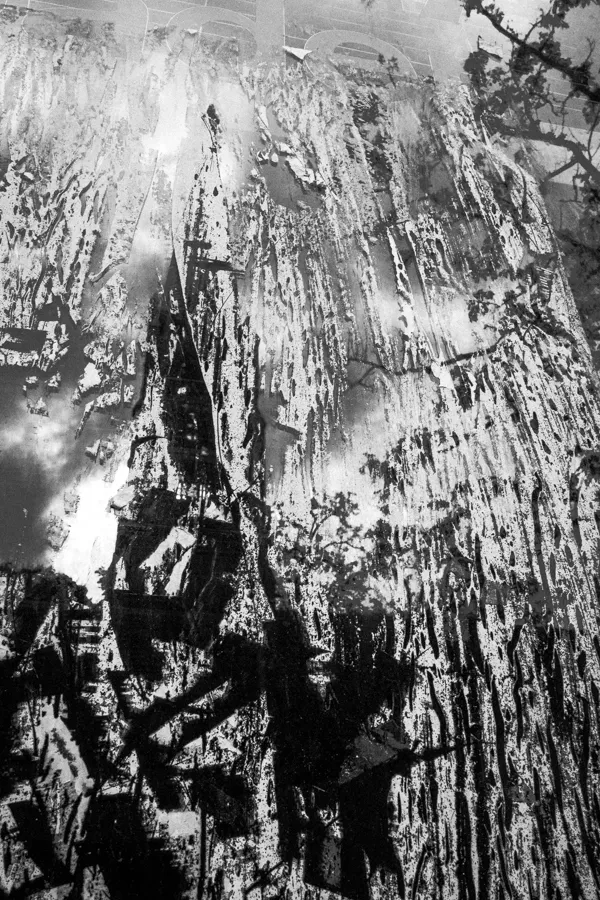 Black and white abstract painting with dripping and splattered textures creating a layered, chaotic effect.