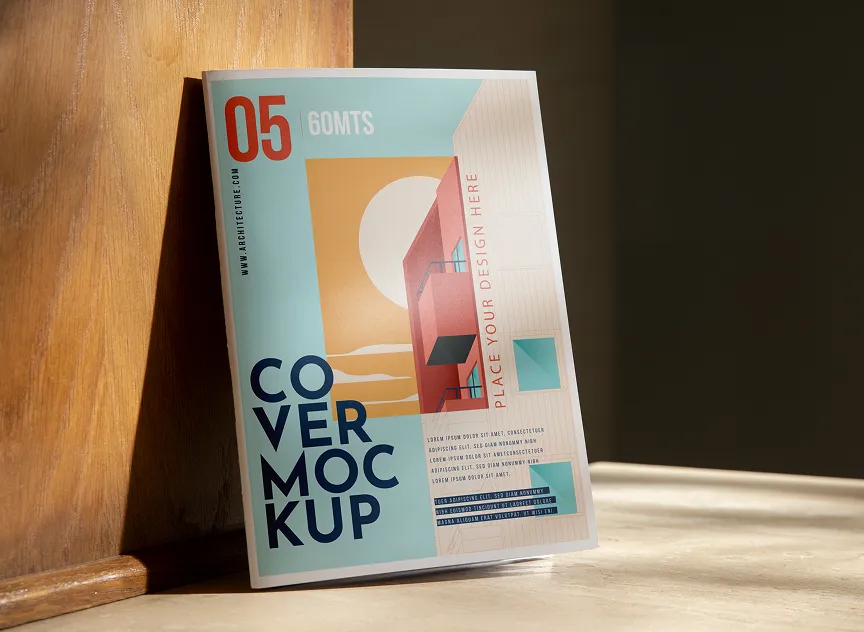Mockup of a magazine cover leaning against a wooden wall, featuring an abstract architectural design with a large sun and shadowed building in pastel colors.