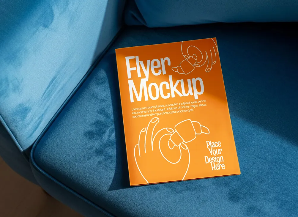 Orange flyer mockup with white line art of hands holding a croissant, placed on a blue fabric sofa.