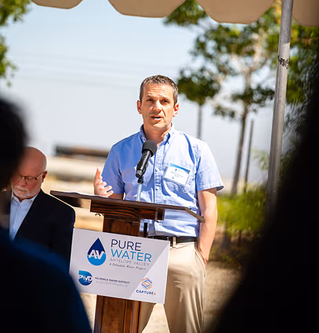 Man speaking at Pure Water Antelope Valley sustainability event outdoors.