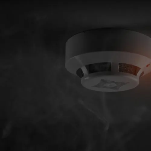 Rookmelder met rook rondom en een oranje waarschuwingslicht aan de zijkant.