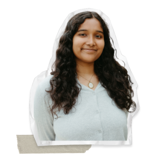 Sticker-style cutout of a smiling Riddhima with long, dark curly hair wearing a light-colored cardigan and a pendant necklace.