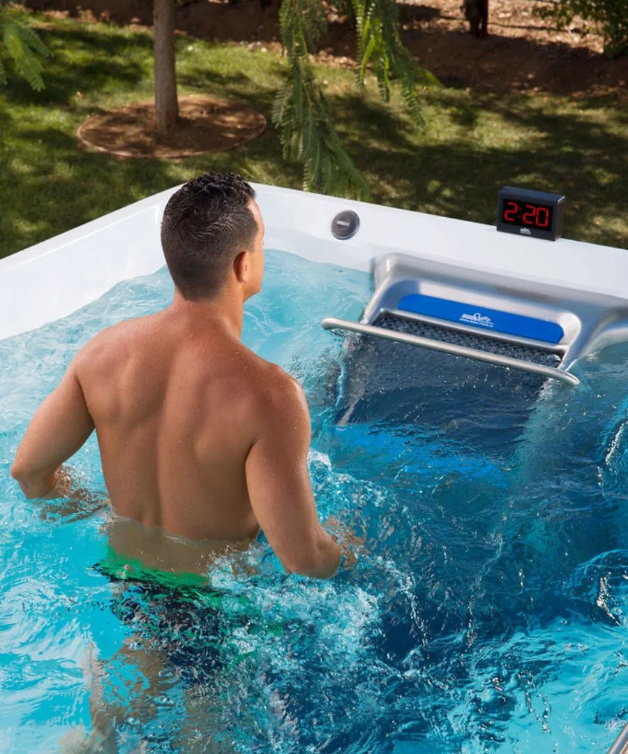 Person in Whirlpool mit blauem Wasser und digitaler Zeitanzeige im Garten