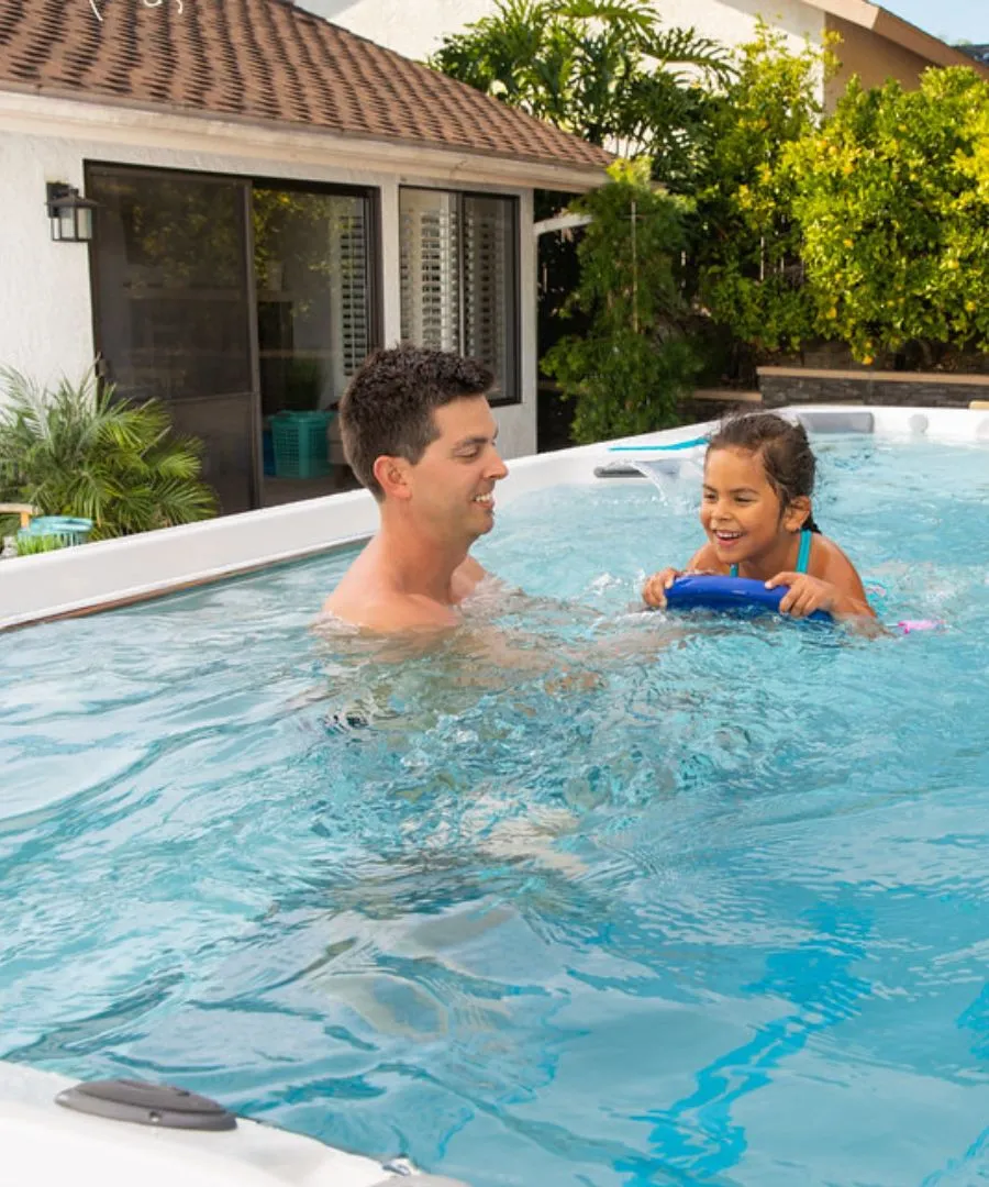 Vater und Tochter spielen fröhlich zusammen im Pool