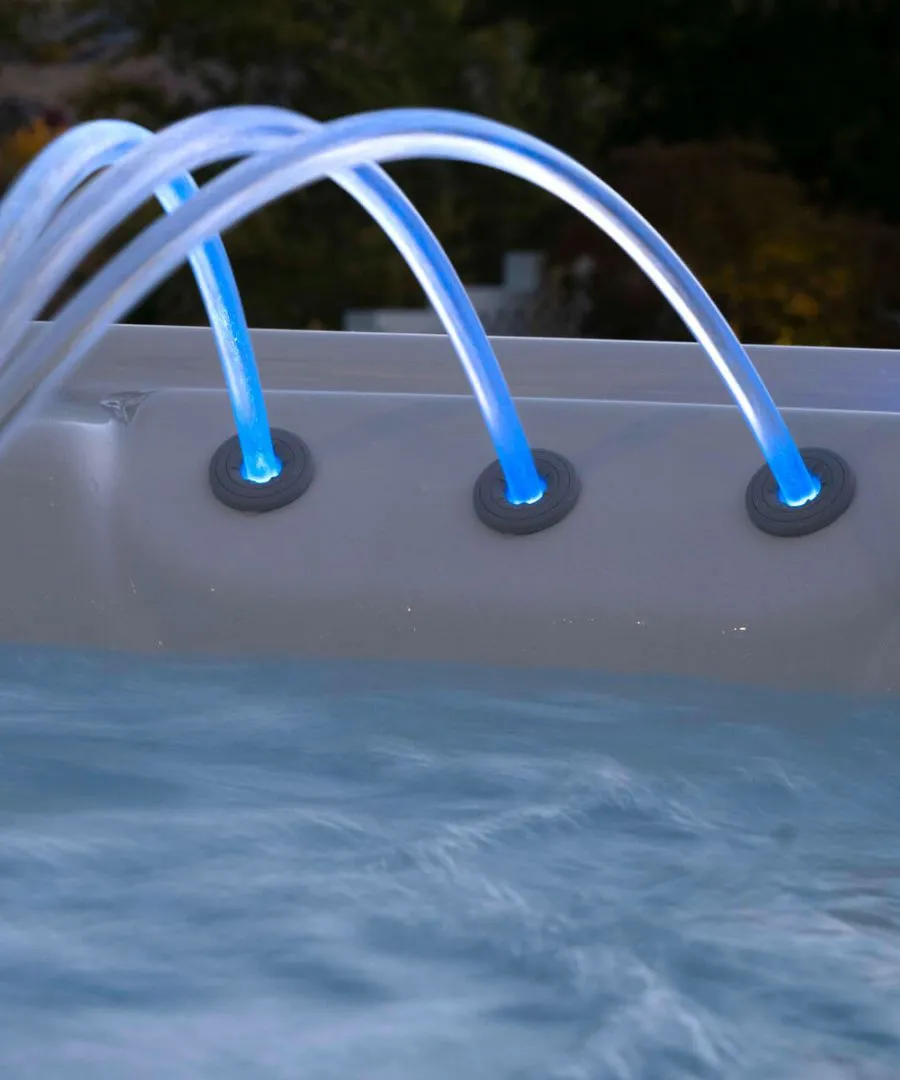 Blaue Wasserstrahl-Düsen in einem Whirlpool mit schimmernder Wasseroberfläche
