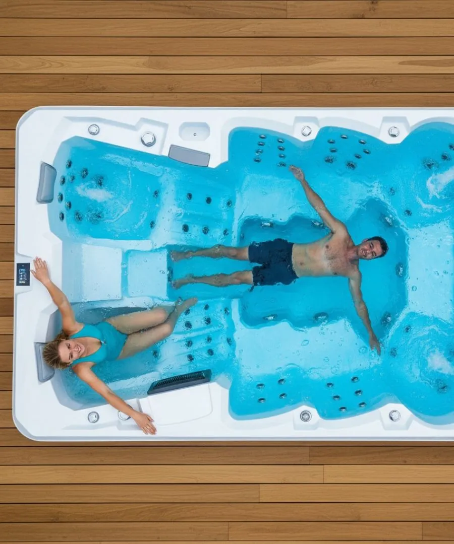 Zwei Personen entspannen in einem blauen Whirlpool auf Holzterrasse