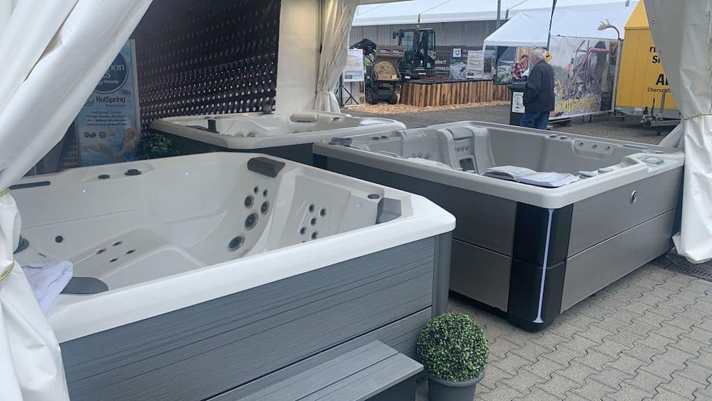 Whirlpools auf einer Messe, weiß und grau, mit Ausstellungszelt im Hintergrund