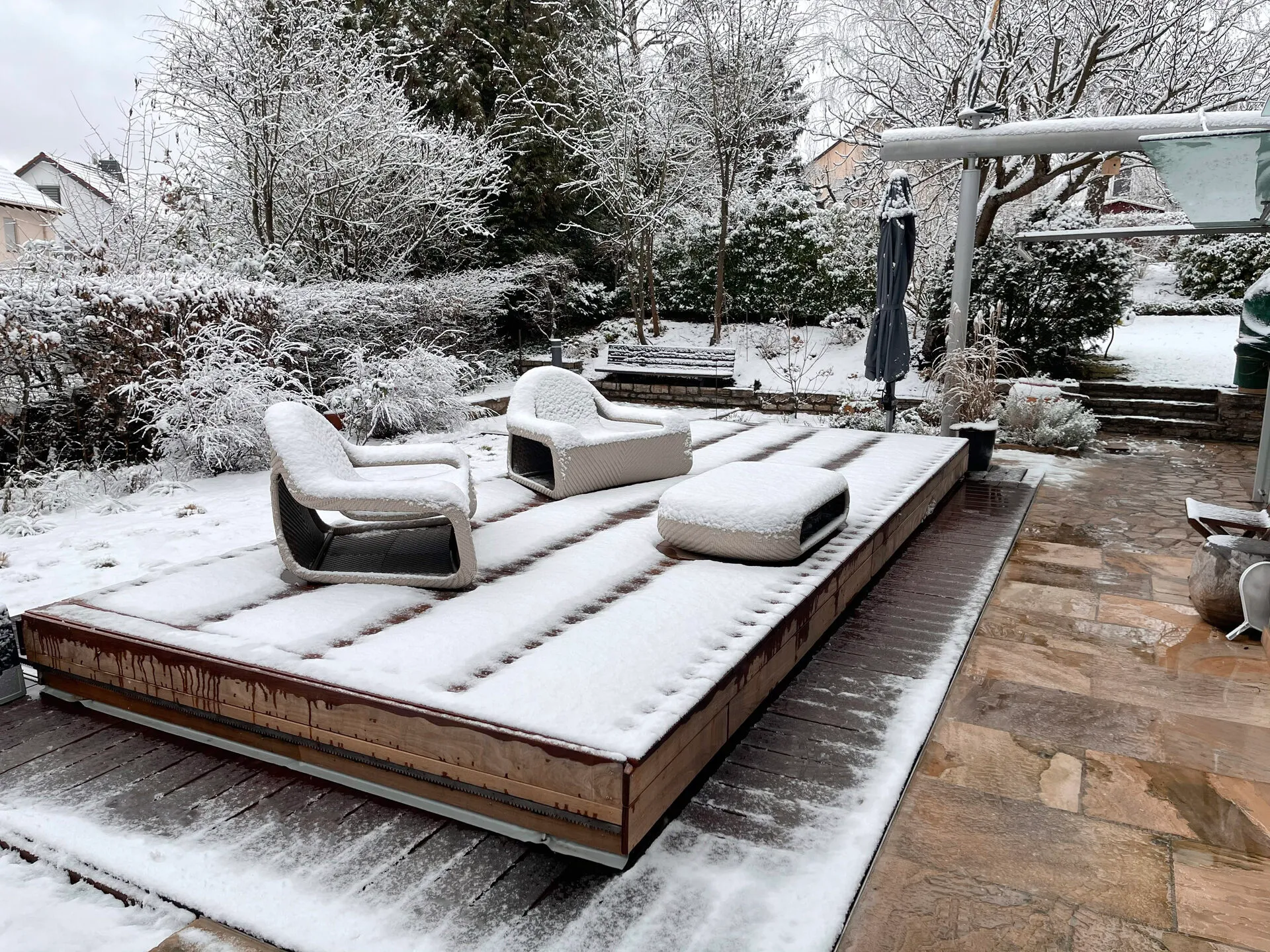 Geschlossene WaluDeck Terrasse trägt im Winter Schnee und Gartenmöbel über dem Pool