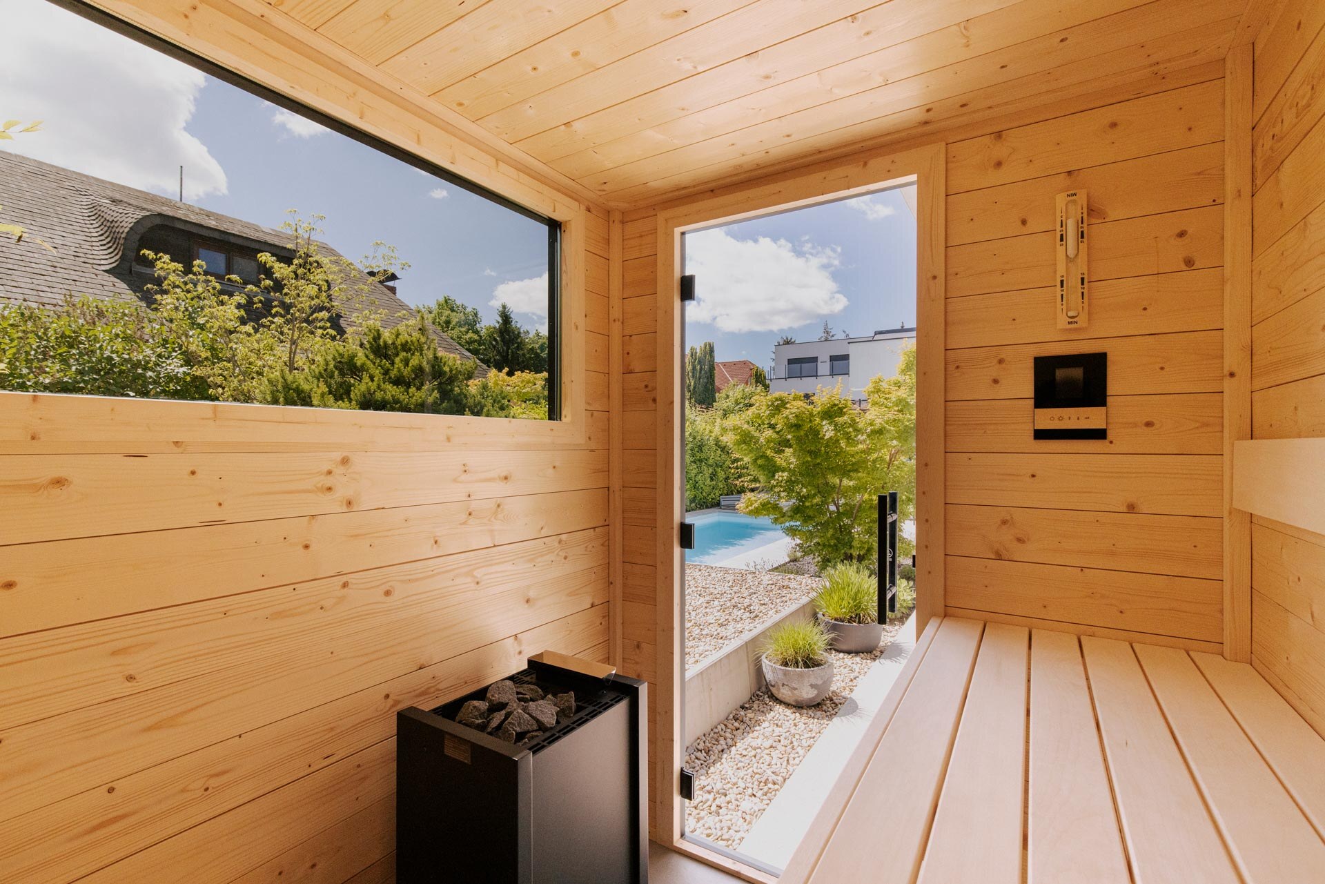 Innenraum einer DEISL Gartensauna aus heller Fichte mit Fenster