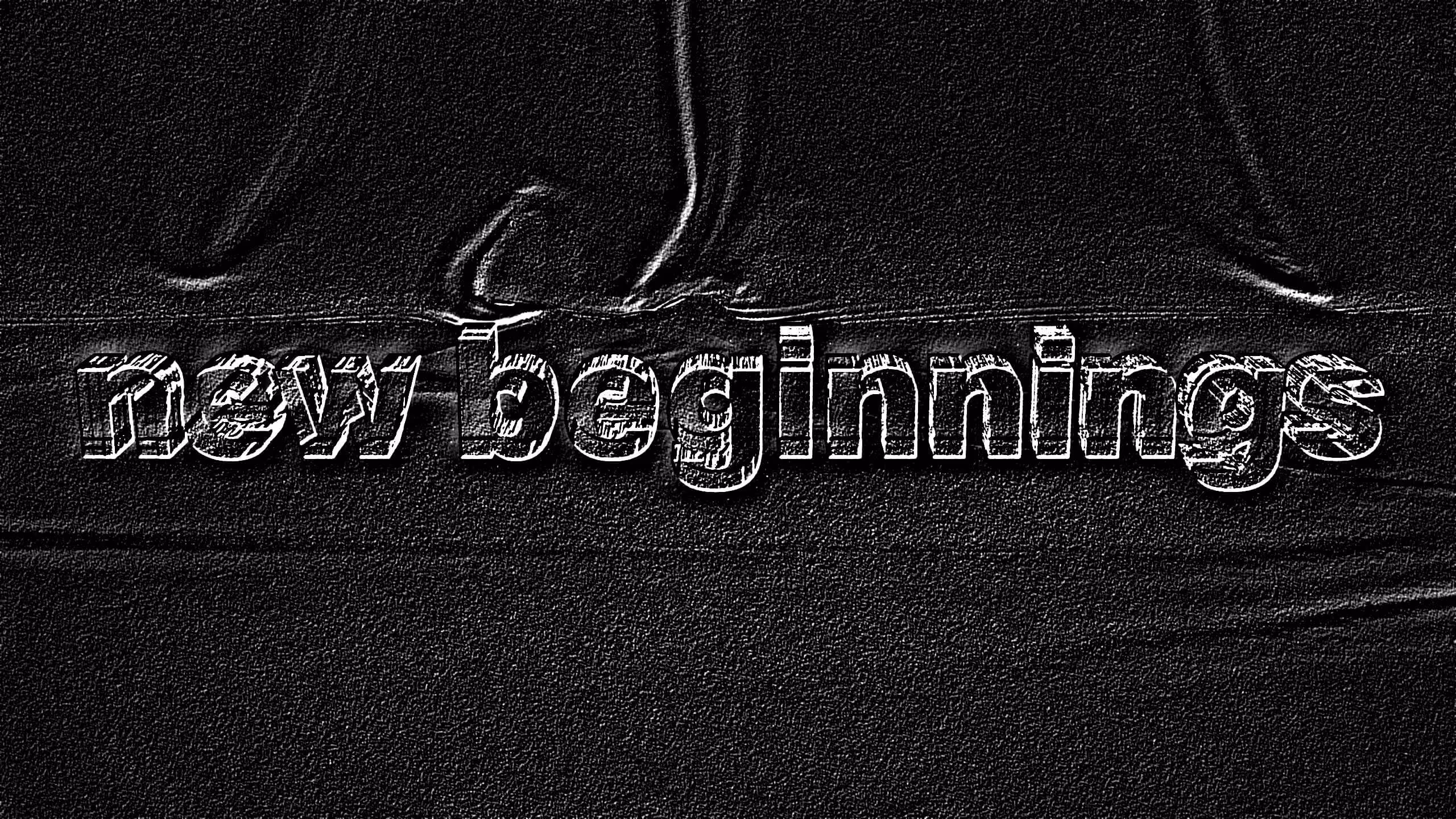 Text reading 'new beginnings' embossed on a textured black fabric background.