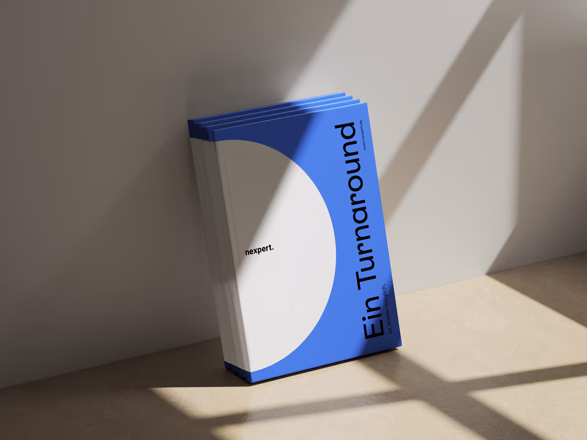 Stack of booklets with blue and white covers leaning against a wall, titled 'Ein Turnaround'.